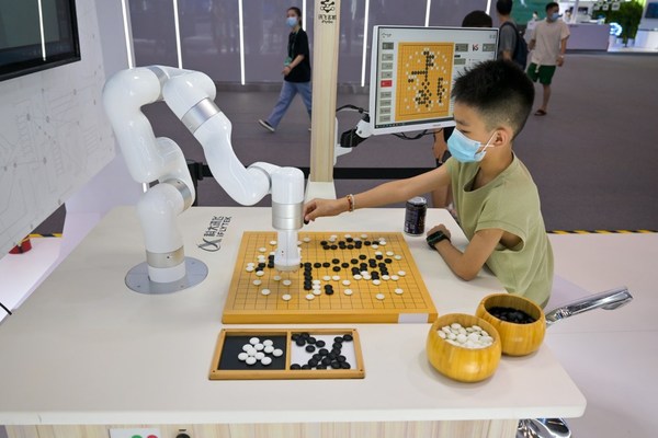 8月22日，小朋友在展场同讯飞玄机（iFlyGo）弈棋机器人下围棋。（摄影/甘侠义）